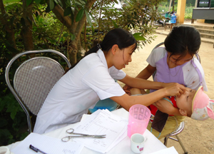 Cán bộ Trạm y tế xã Thanh Hối (Tân Lạc) cho trẻ uống vitamin A tại trạm.